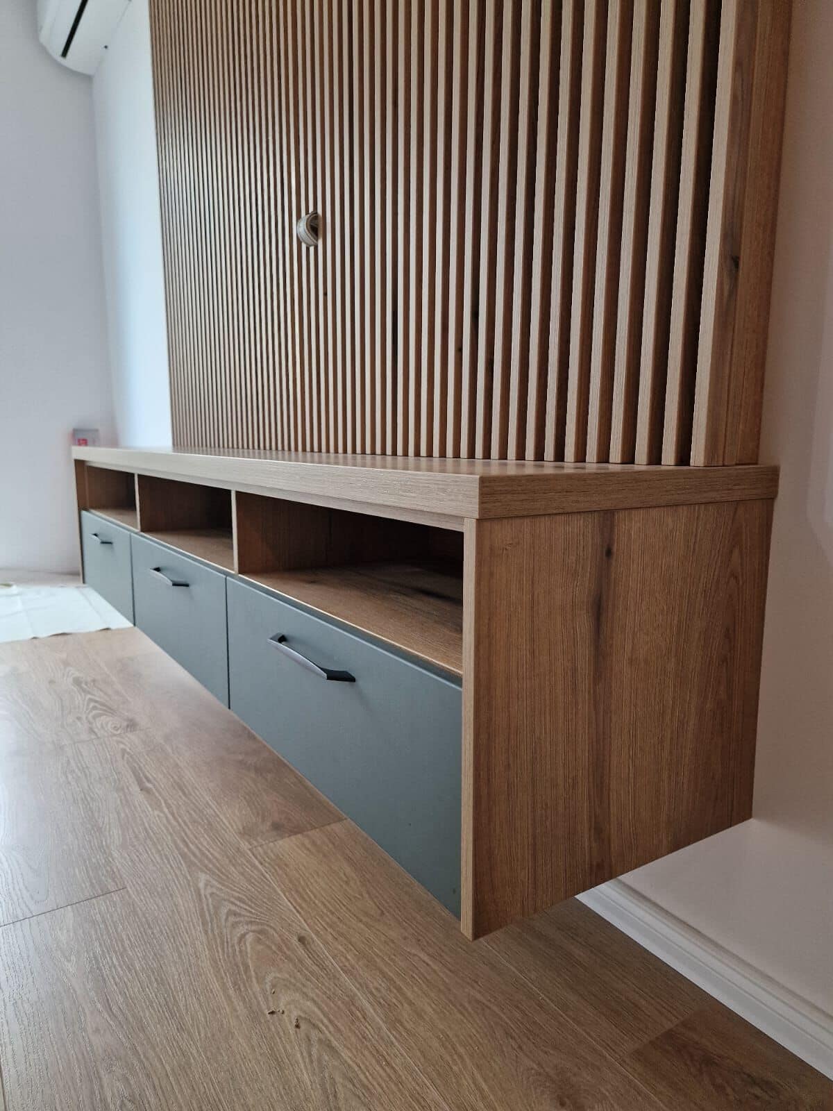 Perete TV cu riflaje — Apartament în Șelimbăr — verde și lemn